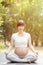 Healthy pregnant woman doing yoga in the garden
