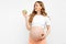 Healthy pregnant woman eating a green apple rich in vitamins on a white background. Pregnancy, healthy food