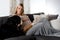 Healthy pregnant woman lying on a couch with her dog.