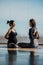 Healthy pregnant woman taking yoga prenatal classes by a personal coach instructor in a sunny gymnasium, with beautiful views.