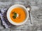 Healthy quinoa carrot soup on rustic light wooden board.