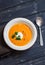 Healthy quinoa carrot soup on rustic light wooden board