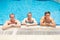 Healthy relaxation. there are three adorable stringly built guys holding by the swimming pool nosing and smiling on the