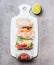 Healthy Rice paper rolls on white cutting board on gray stone background