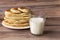 Healthy rustic food. Milk in a bottle, a glass and hot cakes for breakfast. Wheat, corn flour cakes. Wood background.