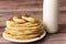 Healthy rustic food. Milk in a bottle, a glass and hot cakes for breakfast. Wheat, corn flour cakes. Wood background.