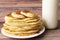 Healthy rustic food. Milk in a bottle, a glass and hot cakes for breakfast. Wheat, corn flour cakes. Wood background.