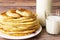 Healthy rustic food. Milk in a bottle, a glass and hot cakes for breakfast. Wheat, corn flour cakes. Wood background.