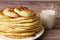 Healthy rustic food. Milk in a bottle, a glass and hot cakes for breakfast. Wheat, corn flour cakes. Wood background.