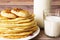 Healthy rustic food. Milk in a bottle, a glass and hot cakes for breakfast. Wheat, corn flour cakes. Wood background.