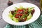 Healthy salad bowl with beef meat, sweet peppers, onions and mixed greens