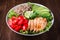 Healthy salad bowl with quinoa, tomatoes, chicken, avocado, lime and mixed greens, lettuce, parsley