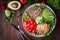 Healthy salad bowl with quinoa, tomatoes, chicken, avocado, lime and mixed greens, lettuce, parsley