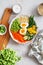 Healthy salad with couscous, carrots, cucumber, green beans, soybeans, corn and an egg on a gray concrete background. Food and