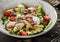 Healthy salad with fillet chicken, avocado, tomatoes, lettuce, greens, pine nuts and sauce in bowl on wooden background. Healthy