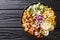Healthy salad of fried chicken, avocado, corn, onion, eggs seasoned with yogurt close-up in a plate. horizontal top view