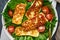 Healthy salad with fried halloumi and tomatoes, closeup top view, keto ketogenic diet