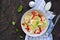 Healthy salad with iceberg lettuce, boiled salmon, sweet pepper and egg in a gray plate on a dark concrete background