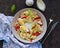 Healthy salad with iceberg lettuce, boiled salmon, sweet pepper and egg in a gray plate on a dark concrete background. Salad