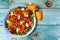 Healthy salad with persimmon, arugula, nuts and feta cheese. Fitness food. Superfoods Vitamin autumn persimmon salad. Dieting and