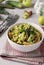 Healthy salad with rhubarb, cucumber, apple and green onion dressed with olive oil in a white bowl on light gray