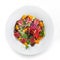 Healthy salad with seared tuna fish, greens, bell pepper and sauce in plate on isolated white background. Healthy food