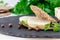 Healthy sandwich with homemade dietary chicken sausage and multi-loaf bread on slate board.