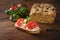 Healthy sandwich, homemade protein bread with cream cheese, tomatoes and basil on a dark rustic wooden table, slimming with low