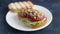 Healthy sandwich with tuna lettuce tomato onion corn frilled bread on white plate panning shot