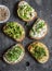 Healthy sandwiches with avocado, hummus, ricotta, cucumber, sunflower sprouts, micro greens and flax seeds. On wooden background,