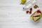 Healthy school lunch box with fresh organic vegetables sandwiches, walnuts, bottle of water and fruits on white wooden background,