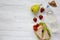 Healthy school lunch box with fresh organic vegetables sandwiches, walnuts, bottle of water and fruits on white wooden background,