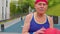 Healthy senior sportsman guy grandfather practicing with ball in sport playground basketball court