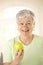 Healthy senior woman holding apple