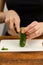 Healthy slicing: Female hands cut vibrant green cucumbers, showcasing the dedication to healthy eating and the