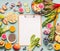 Healthy smoothie ingredients around clipboard with blank paper sheet on light table, top view, frame. Various fruits , vegetables