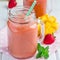 Healthy smoothie with strawberry, mango and banana in glass jars, square