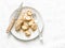 Healthy snack, breakfast - peanut butter, seeds, nuts banana bites on a light background, top view