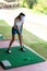 Healthy Sport.  Asian golfer woman swing golf ball practice at golf driving range