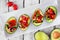 Healthy stuffed avocados with tomato bruschetta, table scene over white wood