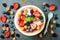 Healthy summer breakfast concept, fruit salad in carved watermelon. Watermelon bowl with yogurt, chia seeds, fresh berries