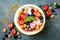 Healthy summer breakfast concept, fruit salad in carved watermelon. Watermelon bowl with yogurt, chia seeds, fresh berries