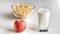 Healthy summer breakfast with corn flakes apple and glass of milk on serving rustic wooden table