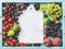 Healthy summer fruit variety. Figs, black and green grapes, sweet cherries, strawberries, peaches on blue painted wooden