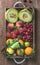 Healthy summer fruit variety. Melon, sweet cherries, peach, strawberry, orange and lemon in wooden tray over rustic