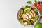 Healthy summer salad with grilled chicken breast, avocado, spinach, cherry berries and tomato. top view