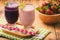 Healthy tasty milk cocktails with strawberries and blueberries on brown wooden background.