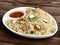 Healthy and tasty Paneer fried rice made of rice, mixed veggies and paneer, served in bowl over a rustic wooden background, Indo