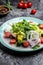 Healthy and tasty salad with fresh vegetables, poached, egg, lettuce, cherry, tomatoes olives and Corn. vertical image. top view