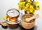 Healthy tea, bucket with coltsfoot flowers and mortar on table